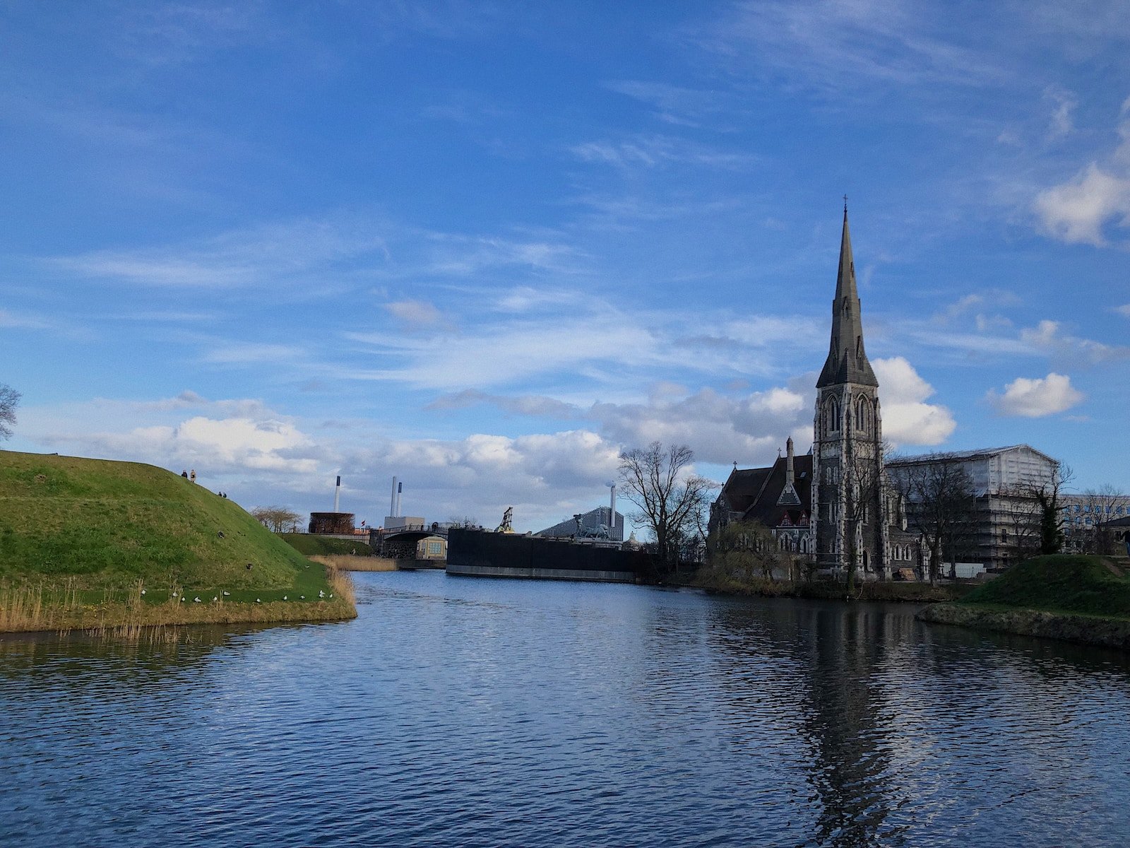 a river with a church steeple in the background